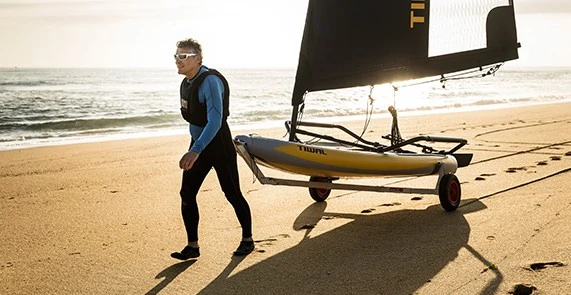 Dériveur Tiwal 3 tracté sur un chariot de plage